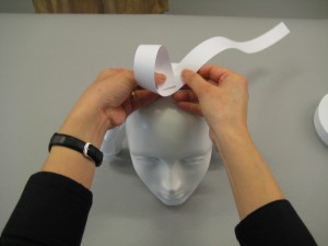 Folded paper being placed on top of mannequin's head